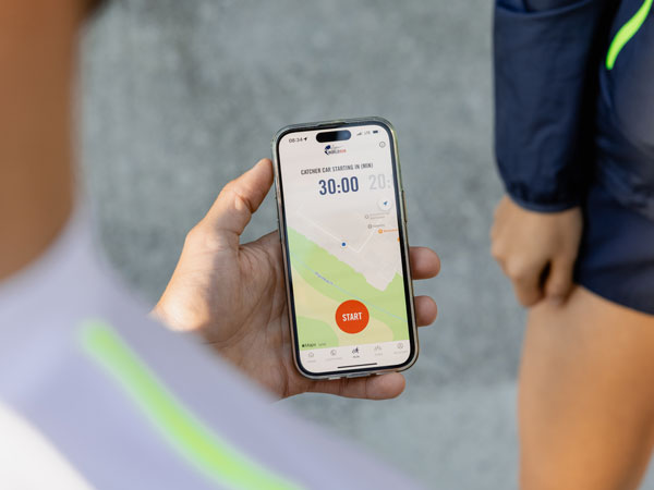 En deltaker i løpet sjekker telefonen sin og venter på at løpet skal starte.