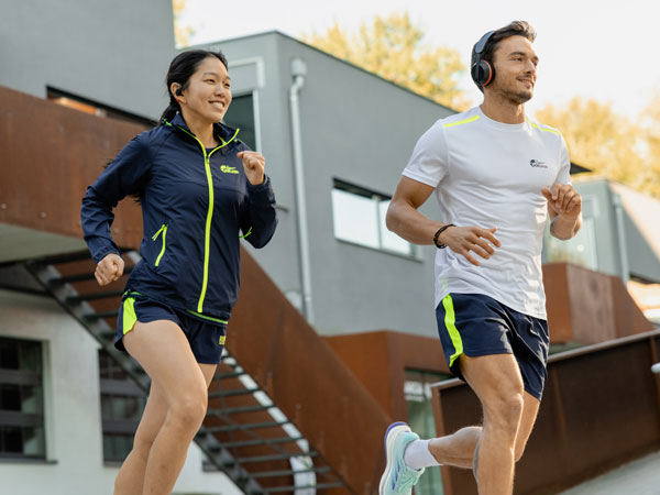 To deltakere i løpet løper med Philips-hodetelefoner.